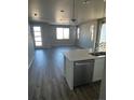 Stainless dishwasher next to a kitchen island with an open layout and hardwood floors at 7360 Watercress Dr, Littleton, CO 80125