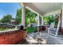 Inviting covered front porch with rocking chairs and brick accents at 3779 Quitman St, Denver, CO 80212