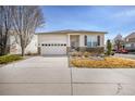 Well-maintained single-story home with stucco siding, stone accents, and attached two-car garage at 1481 Red Poppy Way, Brighton, CO 80601
