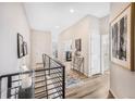 Bright hallway featuring wood floors, iron railings, and stylish decor at 1481 Red Poppy Way, Brighton, CO 80601