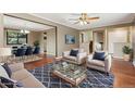 Open-concept living room with hardwood floors, neutral walls, and a cozy seating area with ample natural light at 12408 E Ohio Ave, Aurora, CO 80012
