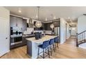 Modern kitchen featuring stainless steel appliances, a center island with seating, and stylish pendant lighting at 13812 Honey Hush Trl, Parker, CO 80134