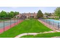 Community view featuring a pool, tennis court, green lawn, and well-maintained townhomes at 4231 S Fairplay Cir # E, Aurora, CO 80014