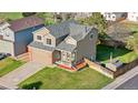 Lovely home with a cozy front porch, a well-kept yard, and an attached two-car garage at 21851 Omaha Ave, Parker, CO 80138