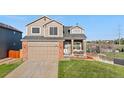 Inviting two-story house featuring a covered porch, a well-maintained lawn, and an attached two-car garage at 21851 Omaha Ave, Parker, CO 80138