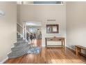 Welcoming foyer with hardwood floors, stairs, and a view into the dining area and kitchen at 21851 Omaha Ave, Parker, CO 80138
