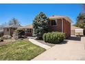 Single-Gathering home with a well-maintained lawn and a paved driveway at 6305 Yukon St, Arvada, CO 80004