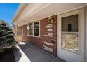 Brick exterior showcasing the home's entrance and front window with natural light at 6305 Yukon St, Arvada, CO 80004