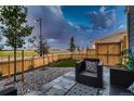 A cozy backyard patio with stone, pea gravel, wood fence, and well-manicured lawn at 6309 N Hanover St, Denver, CO 80238