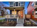 Close-up of a blue two-story home with a red front door and covered porch, creating a welcoming curb appeal at 6309 N Hanover St, Denver, CO 80238
