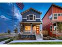 Charming blue two-story home with a red front door and covered porch, creating a welcoming curb appeal at 6309 N Hanover St, Denver, CO 80238