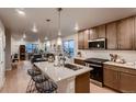 Open concept kitchen with stainless steel appliances, wooden cabinetry, and a center island at 6309 N Hanover St, Denver, CO 80238