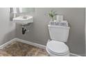 Quaint powder room with a pedestal sink, a toilet with playful decor, and neutral tones that offer a fresh, clean look at 11250 Florence St # 30B, Commerce City, CO 80640