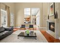 Open-concept living room featuring a fireplace, sleek furniture, and seamless flow to the kitchen area at 26 Royal Ann Dr, Greenwood Village, CO 80111