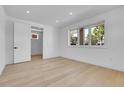 Bright bedroom with light hardwood floors, large windows, and a door to the bathroom at 300 S Franklin St, Denver, CO 80209