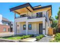 Modern two-story home with stone facade, black trim, wood soffits, and landscaped front yard at 300 S Franklin St, Denver, CO 80209
