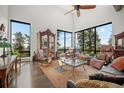 Bright living room boasts floor-to-ceiling windows with breathtaking mountain views and hardwood floors at 8453 S Scenic Dr, Morrison, CO 80465