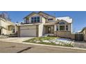 Charming two-story home featuring a two-car garage, brick accents, and a front lawn, with a large front window at 6464 S Swadley Way, Littleton, CO 80127