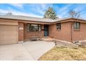 Close-up of a well-maintained brick house featuring an inviting front entry and attached garage at 9231 Irving St, Westminster, CO 80031