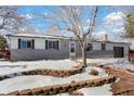 Charming ranch home with a snow-covered front yard at 1557 S Pierson St, Lakewood, CO 80232