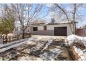 Ranch home with a long driveway and snow-covered yard at 1557 S Pierson St, Lakewood, CO 80232