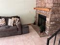 Cozy living room with a stone fireplace, comfortable sofa, and tiled floor for easy maintenance at 2285 S Jasper Way # A, Aurora, CO 80013
