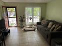 Comfortable living room features tile flooring, a large window, and a sofa with decorative pillows at 2285 S Jasper Way # A, Aurora, CO 80013