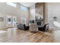 Bright living room features soaring ceilings, wood floors, stone fireplace and updated furniture at 5411 Edenborn Way, Castle Rock, CO 80104
