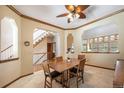Dining room with wood trim, ceiling fan, and a view of the staircase and entry at 9873 Greensview Cir, Lone Tree, CO 80124