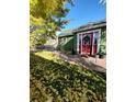 Charming green home with a bright red front door and stone pathway at 6000 W 29Th Ave, Denver, CO 80214