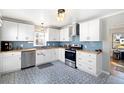 Updated kitchen with white cabinets, stainless steel appliances, butcher block countertops, and patterned tile floors at 4196 Chase St, Denver, CO 80212