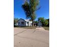 Charming single-story home with white siding, a blue trim, a detached garage, and a large tree at 521 10Th St, Fort Lupton, CO 80621