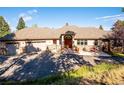 Charming home showcasing a three-car garage and classic architecture and stone accents at 26886 Evergreen Springs Rd, Evergreen, CO 80439