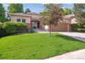 Well-maintained front yard with lush green grass and mature landscaping, creating curb appeal at 1026 Deer Clover Way, Castle Pines, CO 80108