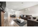 Cozy living room with hardwood floors, comfortable seating, and an adjacent dining area with ample natural light at 724 Ursula St, Aurora, CO 80011