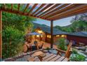 Relaxing backyard patio with a pergola, seating, and lush green landscaping at 2874 Se Grapevine Rd, Idledale, CO 80453