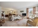 Bright living room with a large window, neutral decor, and comfortable furnishings at 4641 W Ponds Cir, Littleton, CO 80123