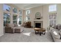 Sunlit living room with a fireplace, large windows, and comfortable seating at 6078 Bridle Path Ln, Parker, CO 80134