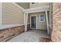 Covered front entrance featuring stone accents, modern door, and clean walkway leading to the home at 9719 Albion Ln, Thornton, CO 80229