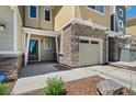 Inviting townhome featuring a stone facade, attached garage, and well-maintained landscaping at 9719 Albion Ln, Thornton, CO 80229