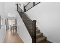 Bright hallway featuring hardwood floors, a staircase with dark wood railings, and a glimpse of the dining area at 9719 Albion Ln, Thornton, CO 80229