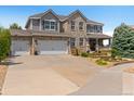 Charming two-story home with a well-maintained lawn, brick accents, and a two-car garage and inviting front porch at 11921 S Black Horn Cir, Parker, CO 80134