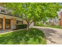 Charming townhome featuring a brick facade, well-maintained lawn, and mature trees at 387 Upham St, Lakewood, CO 80226