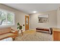 Cozy living room featuring a large window, neutral walls, and inviting seating area at 387 Upham St, Lakewood, CO 80226