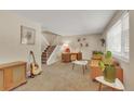 Spacious living room area with staircase, guitar, artwork, and comfortable seating at 387 Upham St, Lakewood, CO 80226