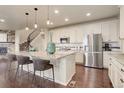 Bright kitchen with a large center island, stainless appliances, and hardwood floors at 7099 E 123Rd Pl, Thornton, CO 80602