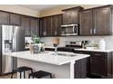 Modern kitchen with stainless steel appliances, center island, and sleek countertops at 1380 S Boston Ct # A, Denver, CO 80247