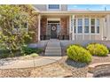 Inviting covered entry and front porch with brick accents and curated landscaping at 27290 E Nova Cir, Aurora, CO 80016