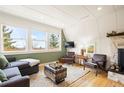 Cozy living room with three large windows, wooden floors, and a stylish area rug at 352 Apache Rd, Evergreen, CO 80439