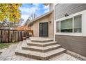 Exterior view of a backyard entrance with stone steps and wood siding at 11687 Decatur Dr, Westminster, CO 80234